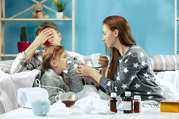 Image showing The young parents with sick daughter at home. The ill family.