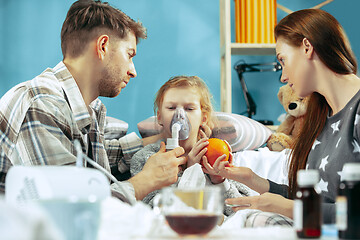 Image showing The young parents with sick daughter at home. The ill family.