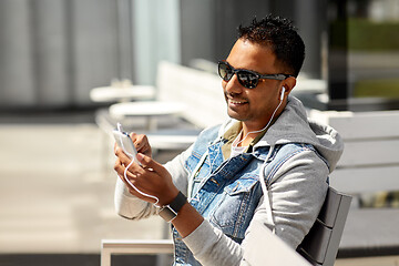 Image showing man with earphones and smartphone on city street