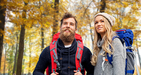 Image showing smiling couple with backpacks hiking in autumn