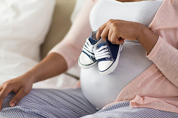 Image showing pregnant african woman with little baby bootees