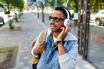 Image showing indian man in headphones with backpack in city