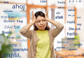 Image showing stressed asian woman holding to her head