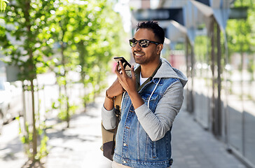 Image showing man recorving voice message on smartphone in city