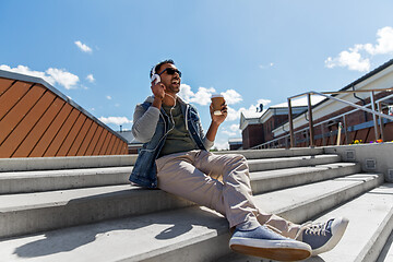 Image showing man in headphones listening to music on roof top