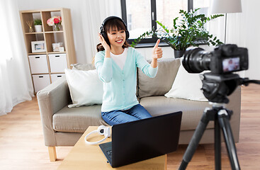 Image showing female blogger with headphones making video blog