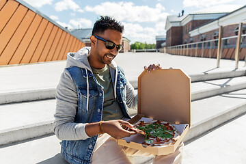 Image showing indian man eating takeaway pizza on roof top