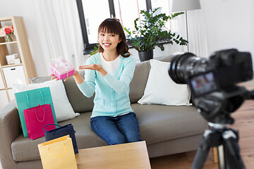 Image showing asian female blogger with gift bag recording video