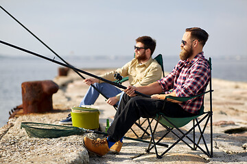 Image showing happy friends with fishing rods on pier