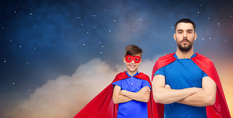 Image showing father and son in superhero capes over night sky