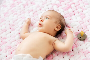 Image showing baby girl in diaper lying with pacifier on blanket