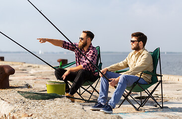 Image showing male friends with fishing rods on pier