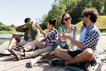 Image showing friends drinking beer and cider on lake pier