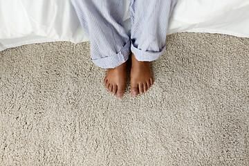 Image showing feet of african american woman sitting on bed