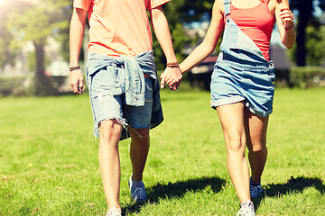 Image showing happy teenage couple walking at summer park