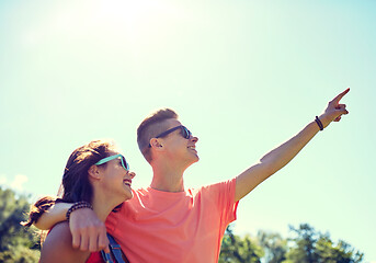 Image showing happy couple pointing finger at summer park