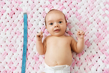 Image showing baby girl lying with measure tape on blanket