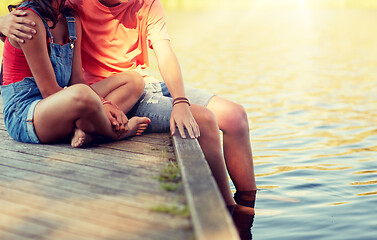 Image showing happy teenage couple sitting on river berth