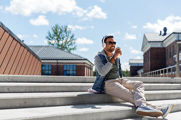 Image showing man in headphones listening to music on roof top