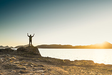 Image showing Man exploring the coast line at sunset