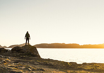 Image showing Man exploring the coast line at sunset