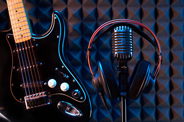 Image showing Studio microphone with professional headphones and black electric guitar