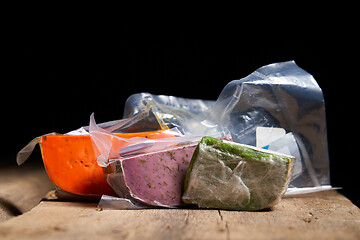 Image showing Three different gourmet cheeses on rough woode planks