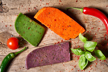 Image showing Three different cheeses on rough wooden planks: lavender, paprik