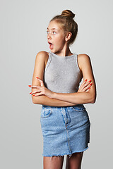 Image showing Teen girl in denim skirt looking to side