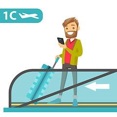 Image showing A traveller in an airport with a smartphone and a suitcase.