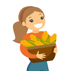 Image showing A white happy woman with a basket of corncobs.