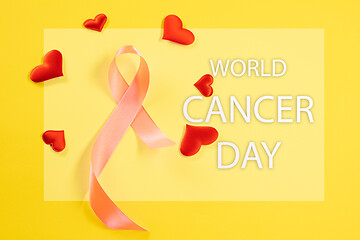 Image showing the text world cancer day and a pink ribbon on a table background