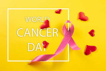 Image showing the text world cancer day and a pink ribbon on a table background