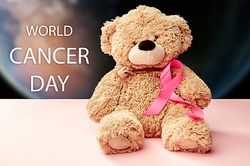 Image showing the text world cancer day and a pink ribbon on a table background