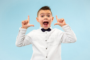 Image showing Isolated on blue young casual boy shouting at studio