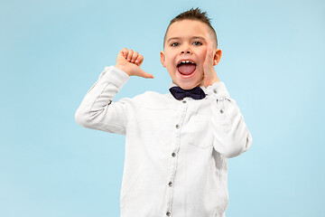 Image showing Isolated on blue young casual boy shouting at studio