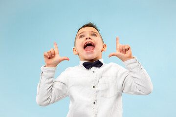 Image showing Isolated on blue young casual boy shouting at studio