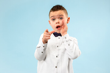 Image showing The teen boy whispering a secret behind her hand over blue background