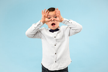 Image showing Portrait of the scared teen boy on blue