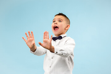 Image showing Portrait of the scared teen boy on blue