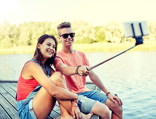 Image showing happy teenage couple taking selfie on smartphone