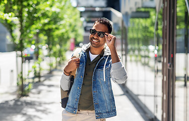 Image showing indian man in sunglasses with backpack in city