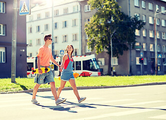 Image showing teenage couple with skateboards on city street