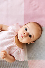 Image showing sweet baby girl lying on knitted blanket