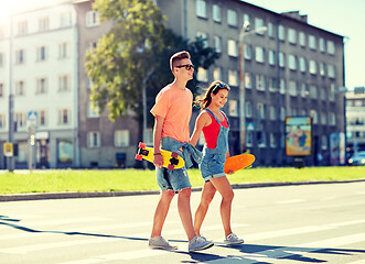 Image showing teenage couple with skateboards on city street