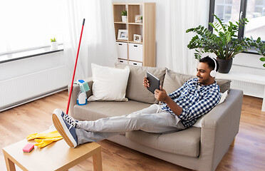 Image showing indian man in headphones after cleaning home