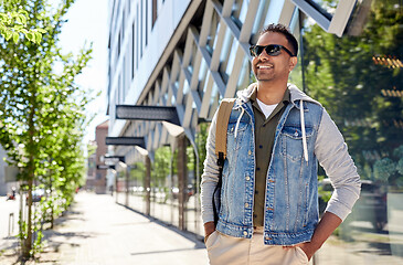 Image showing indian man with backpack walking along city street