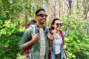 Image showing mixed race couple with backpacks hiking in forest