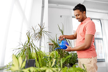 Image showing indian man watering houseplants at home