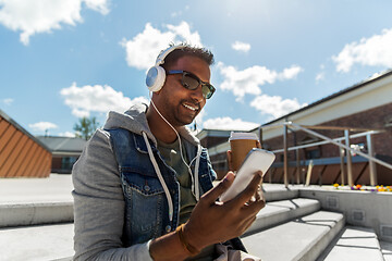 Image showing man with smartphone and headphones on roof top